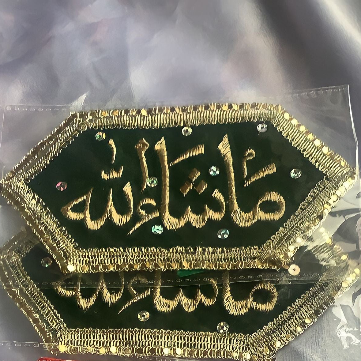 Two embroidered patches, one green and one red, with gold lettering on a clear background.